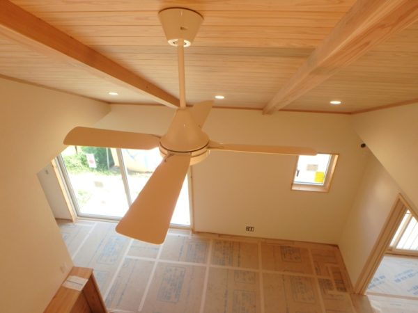開放感ある無垢材の勾配天井と空気循環ファン
