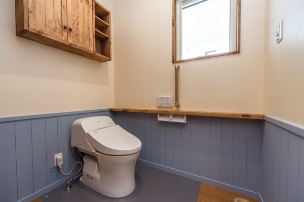 水色の腰壁や汚れの落ちやすいハイドロセラで清潔なトイレ